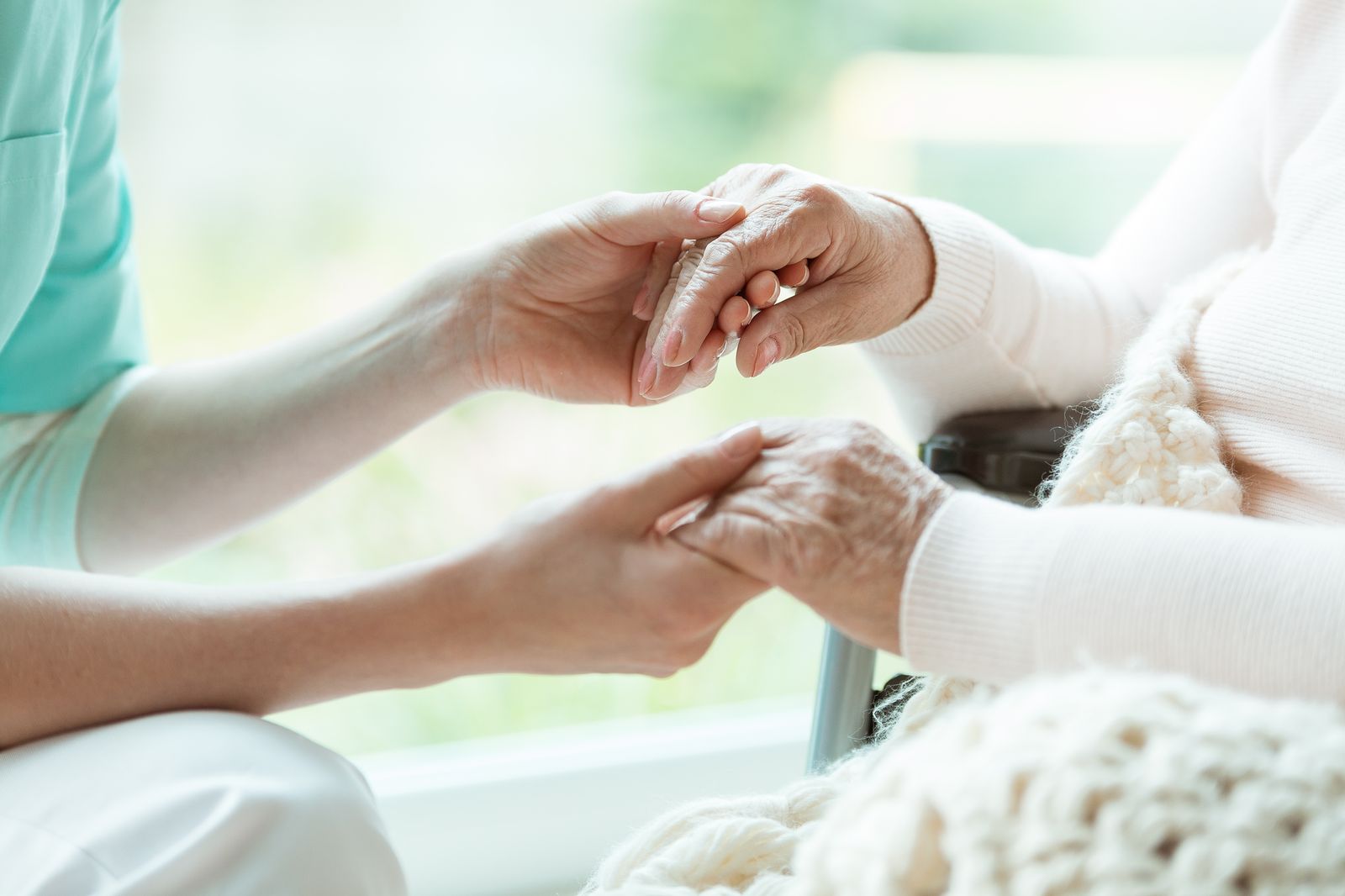 Intensivpflege – Pflegerin hält Hand der Patientin