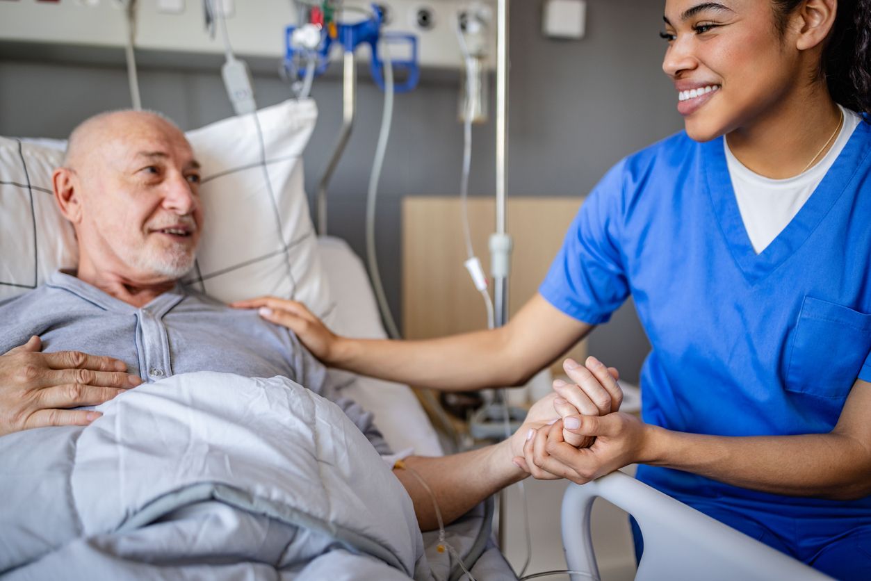 Intensivpflege – Pflegerin hält Hand des Patienten